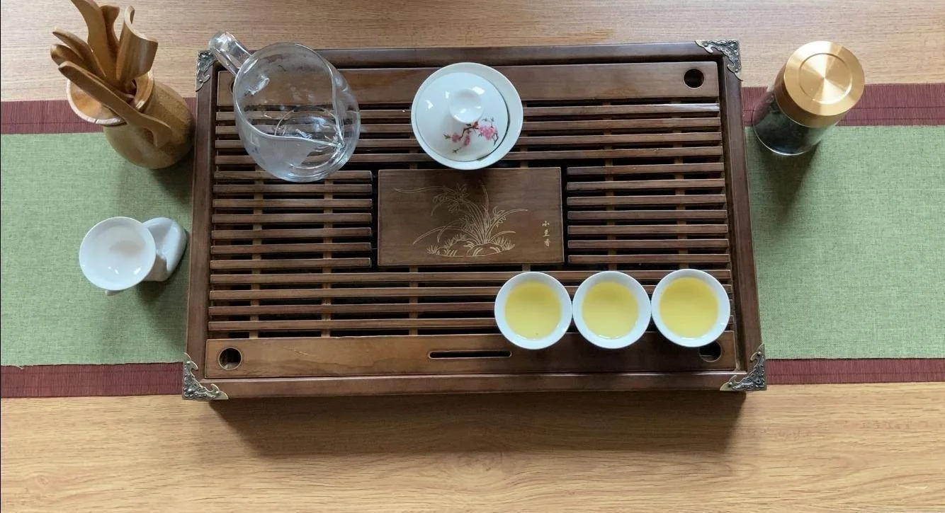 A gaiwan, fairness pitcher, small cups and tea tray arranged after tea has been poured.
