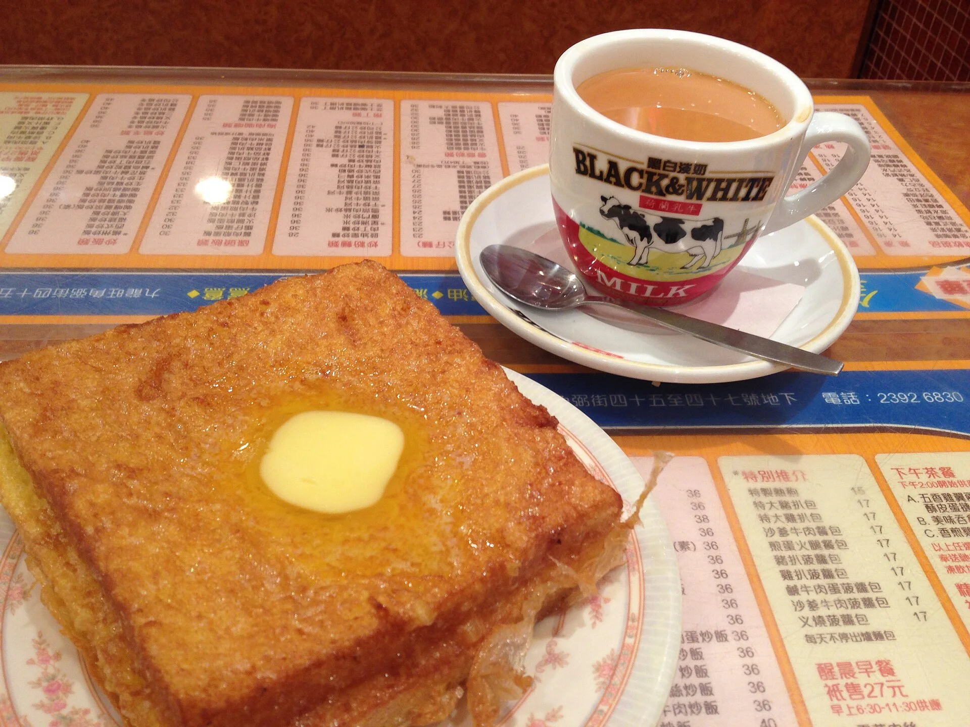 Hong Kong-style French toast and a glass of milk tea on a cha chaan teng table.