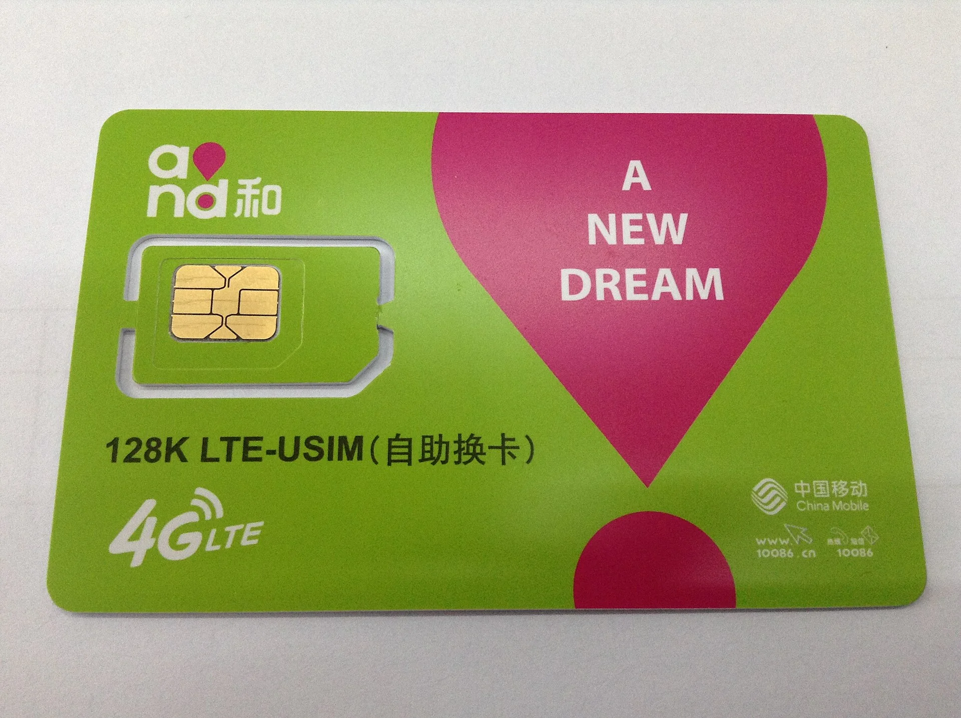 A China Mobile 4G LTE USIM card in its green and magenta retail carrier.