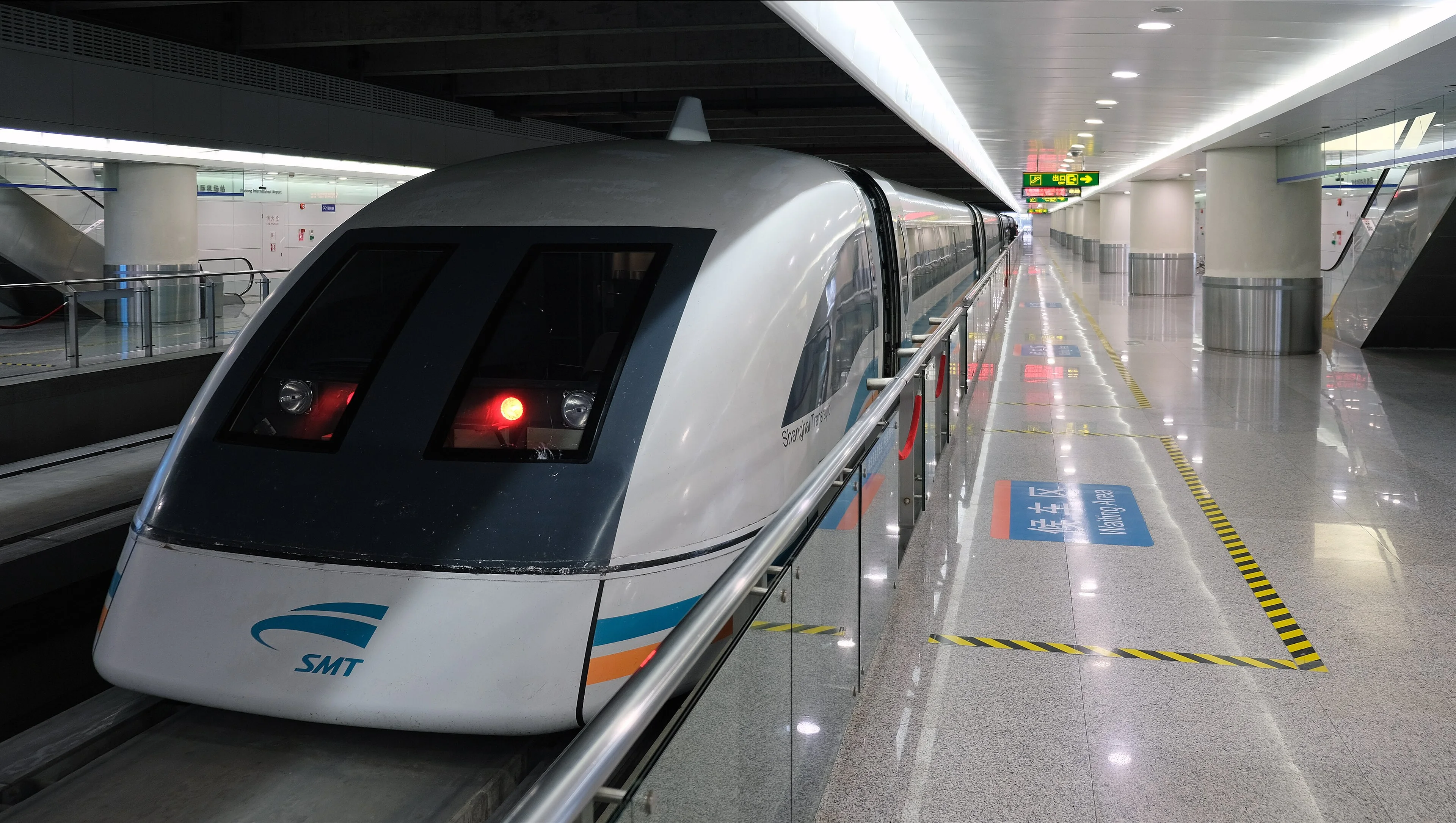 A Shanghai maglev train waits beside a bright platform at Pudong International Airport station.