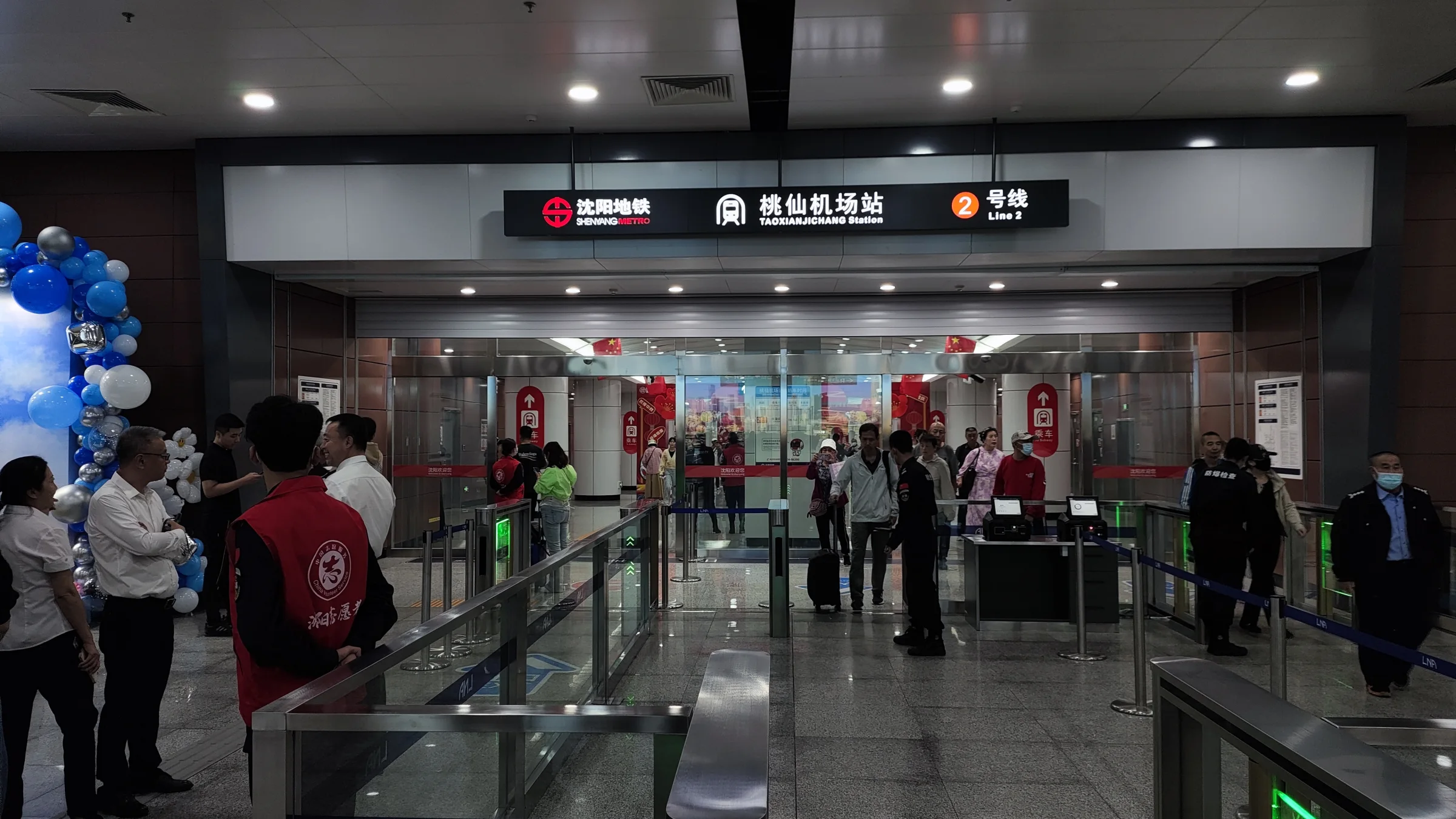 Passengers pass through the signed entrance connecting Shenyang Taoxian Airport Terminal 3 with Metro Line 2.