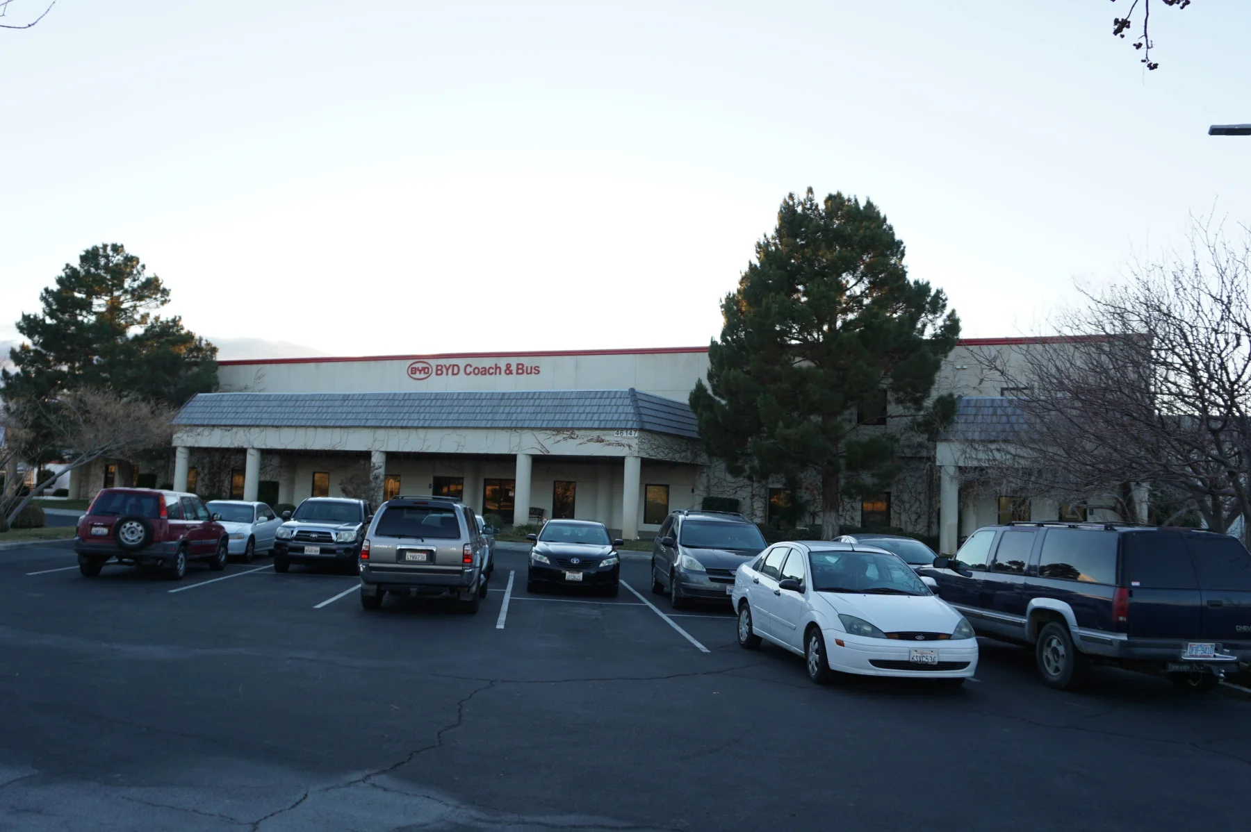 The BYD Coach and Bus facility in Lancaster, California, with the company sign visible above the entrance.